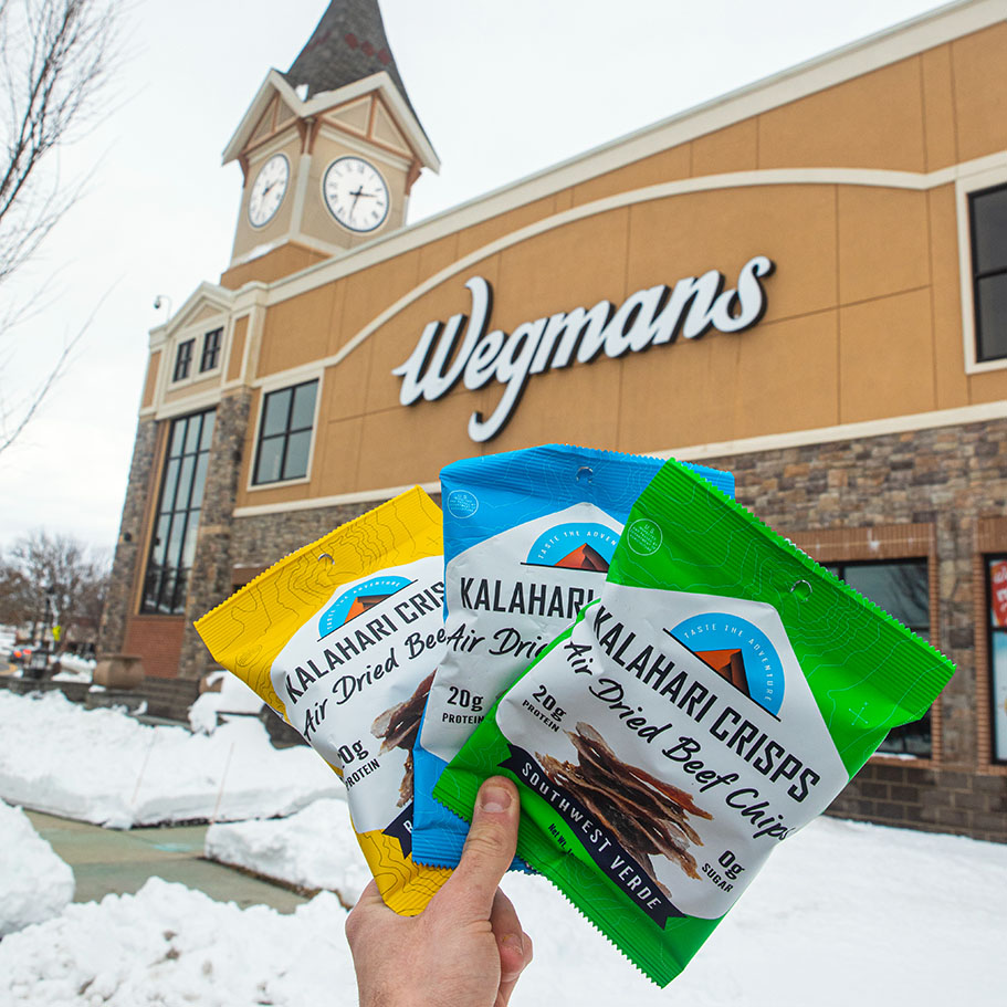 crisps held in hand in front of Wegmans store