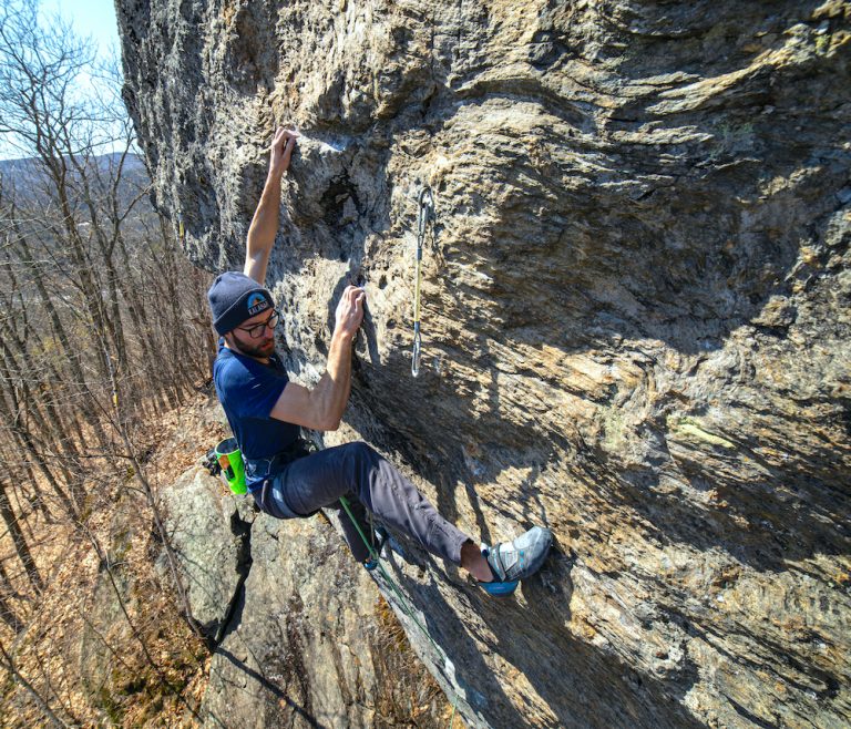 man climbs rock face