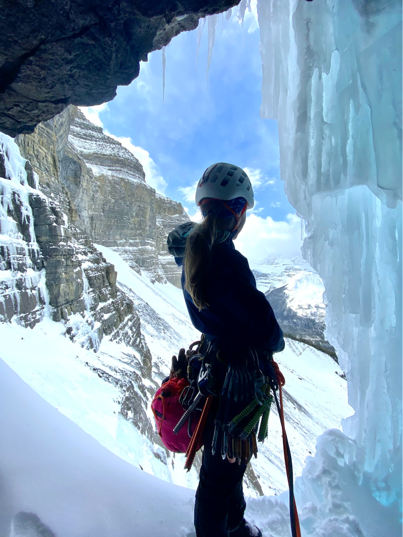 woman in an ice cave wearing climbing gear